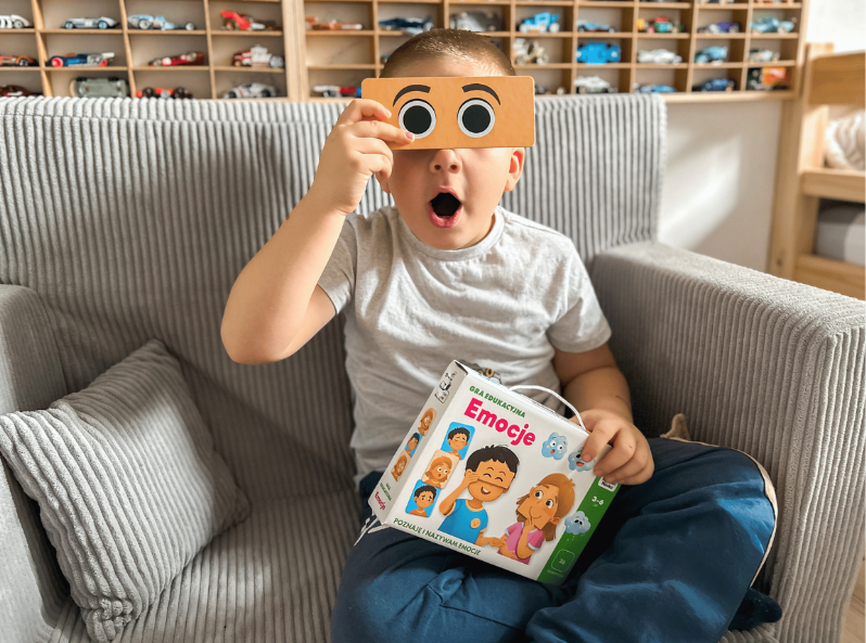 Chłopiec gra w grę Emocje. Gra edukacyjna od Kapitana Nauki –do nauki rozpoznawania emocji dla dzieci 3–6 lat