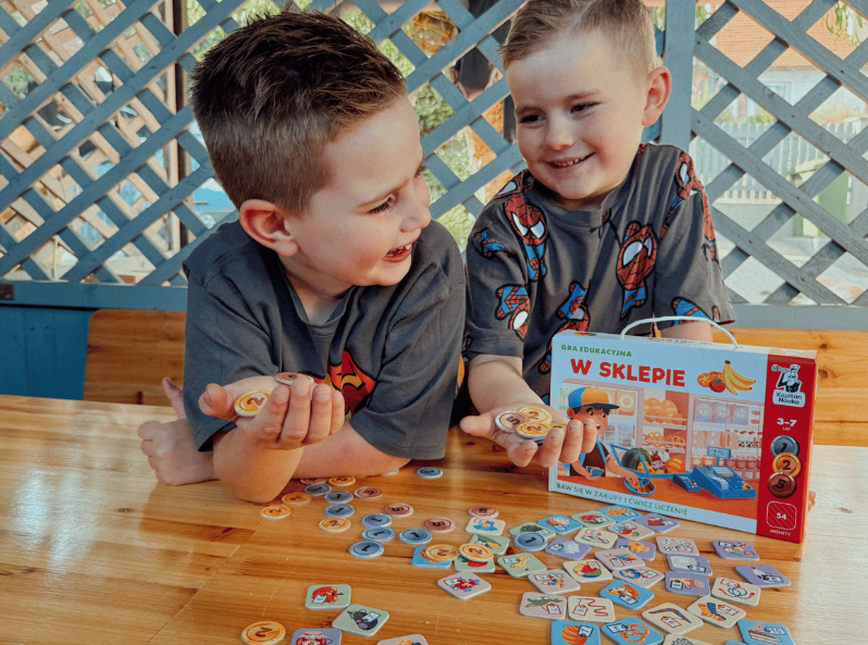 Chłopcy grają w grę W sklepie. Gra edukacyjna od Kapitana Nauki