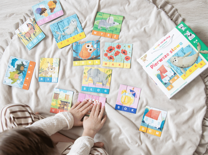 Puzzle edukacyjne. Pierwsze słowa – puzzle do nauki czytania pierwszych wyrazów dla przedszkolaków 3–6 lat rozłożone na dywanie