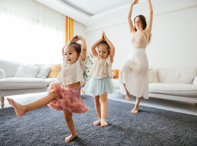 przedszkolaki i ich opiekun tańczą wesoło w domu