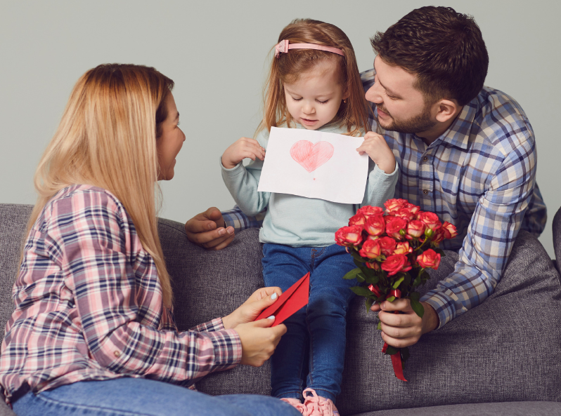 Dziewczynka pokazuje mamie kartkę z narysowanym serduszkiem – prezent DIY na dzień mamy
