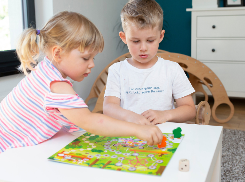 Dwoje dzieci grających w grę logopedyczną Leśny bal Kapitana Nauki