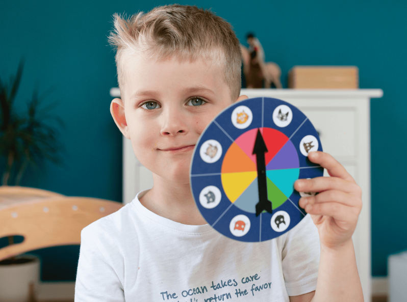 Chłopiec trzyma koło losujące z Gry Bingo Koty Kapitana Nauki