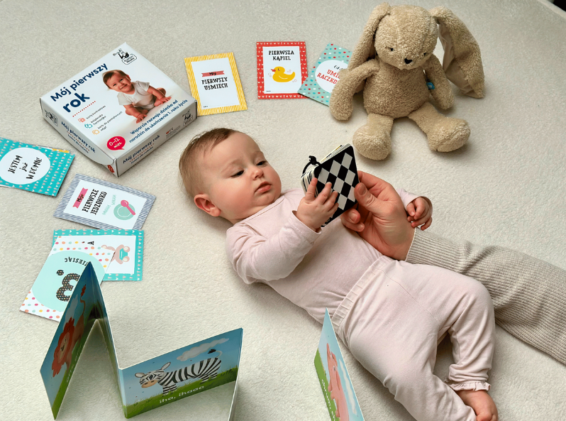 Małe dziecko leżące z zestawem Mój pierwszy rok z kartami kontrastowymi dla malucha