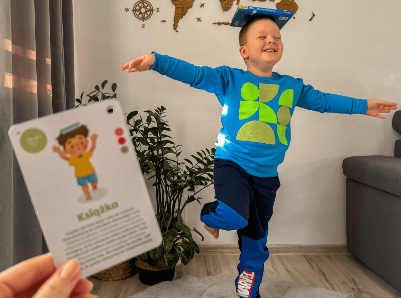 chłopiec bawi się kartami Fikaj, brykaj! – gra ruchowa Kapitana Nauki