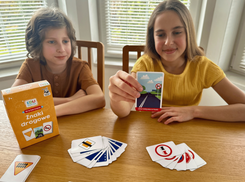 Dzieci grają w Znaki drogowe EDUseria gra karciana i pokazują zawartość kart