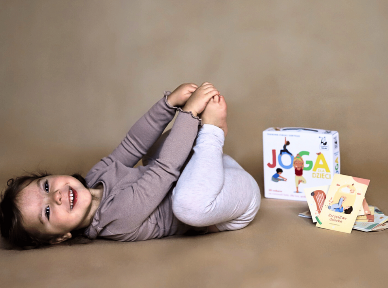 Dziewczynka korzysta z kart Kapitana Nauki Joga dla dzieci - trening ciała i umysłu, regulowanie emocji przez ruch
