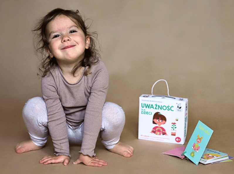 Dziewczynka ćwiczy z kartami Uważność dla dzieci. Trening mindfulness