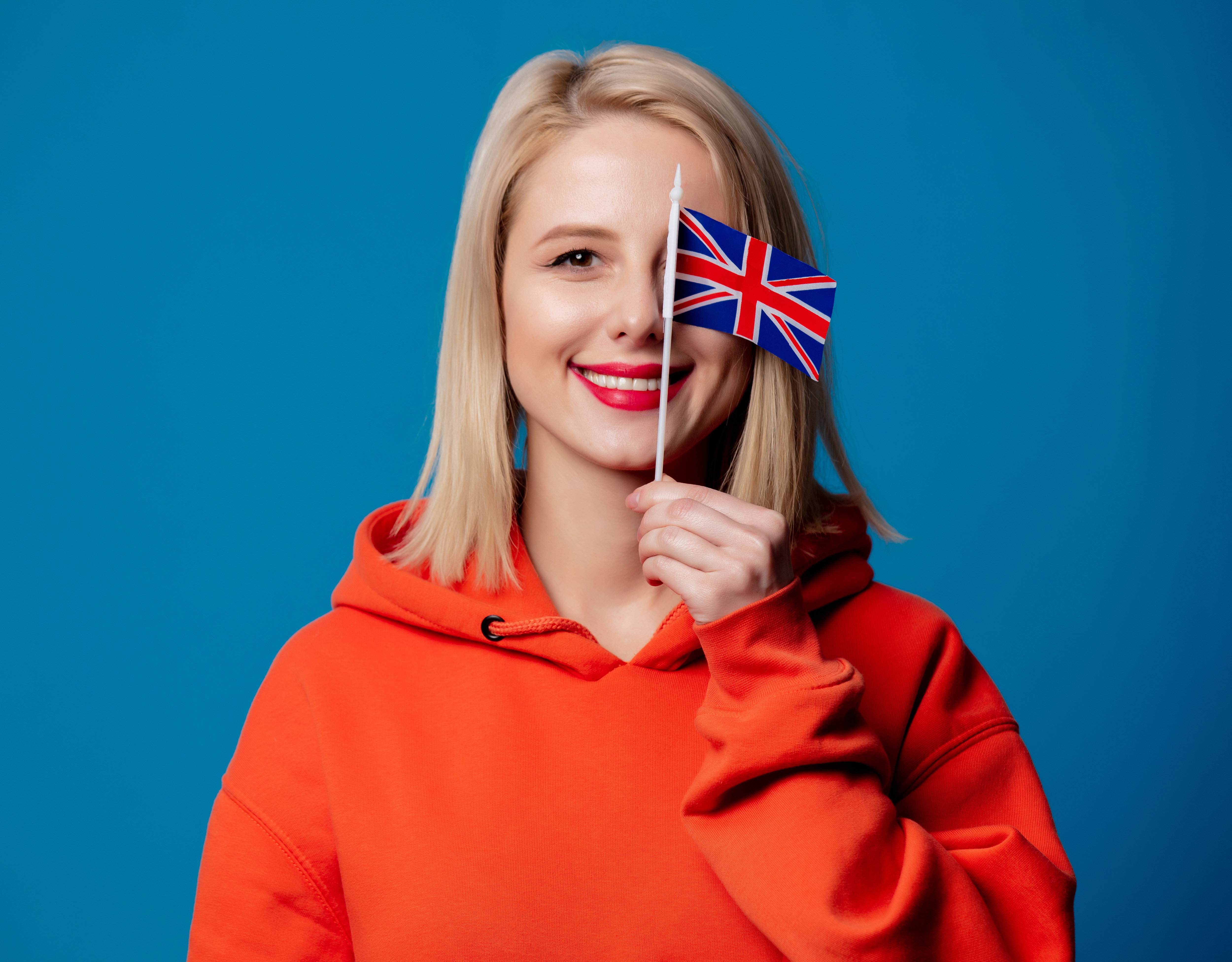 Kobieta z blond włosami trzymka brytyjską flagę w dłoni